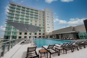 una piscina con sillas y un edificio en Marriott Fort Lauderdale Airport, en Dania Beach