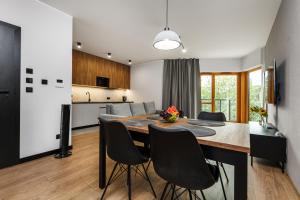 a kitchen and dining room with a table and chairs at Nadmotławie Residence by HappyStay in Gdańsk