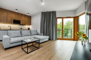 un soggiorno con divano e tavolo di Nadmotławie Residence by HappyStay a Danzica