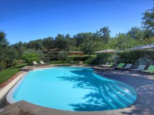 ローロ・チュッフェンナにあるDetached villa for 6 pers with outdoor swimming poolの大きなスイミングプール(椅子、パラソル付)