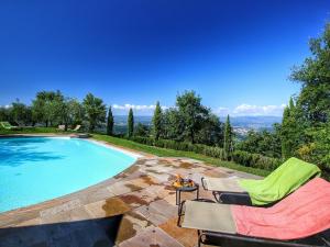 - une piscine avec 2 chaises et une table à côté dans l'établissement Detached villa for 6 pers with outdoor swimming pool, à Loro Ciuffenna