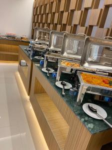 uma linha de buffet com muitas bandejas de comida em Dolphin Continental Hotel em Kuwait