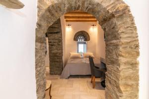 a bedroom with a bed in a stone archway at PG Houses in Kalloni Village - PHouse in Kalloni Tinou