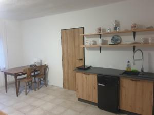 uma cozinha com uma mesa e um frigorífico preto em Snina studio apartment em Snina