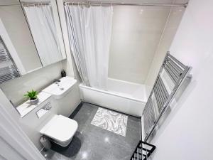 een witte badkamer met een toilet en een wastafel bij London 2 Beds Flat Next to the City in Londen