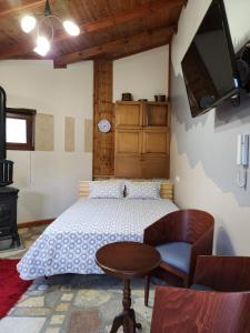 Schlafzimmer mit einem Bett, einem Tisch und einem TV in der Unterkunft Guest House Seferi Ξενωνας Σεφερη in Gjirokastër
