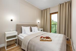 a bedroom with a bed with a tray of food on it at Nadmotławie Residence by HappyStay in Gdańsk