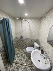 a bathroom with a toilet and a sink and a shower at HOTEL UZBEGIM in Urganch