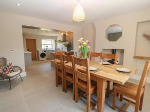 a dining room and kitchen with a wooden table and chairs at The Old House in Northallerton