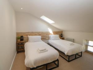 two beds in a room with white sheets at The Old House in Northallerton