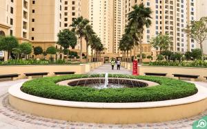 a fountain in a park with benches and buildings at Nasma Luxury Stays- Incredibly Spacious Apt Overlooking The Marina in Dubai