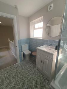 a bathroom with a sink and a toilet and a mirror at Walpole BACK House sleeps 6-8 in Margate