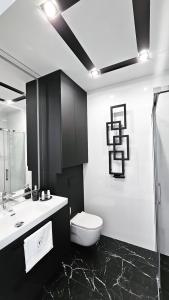 a black and white bathroom with a toilet and a sink at Apartament Wietrznia z tarasem, ogródkiem, parkingiem, na prestiżowym osiedlu obok rezerwatu przyrody NEW!!! in Kielce
