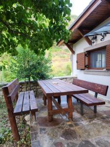 einem Picknicktisch aus Holz und zwei Bänken unter einem Baum in der Unterkunft Guest House Seferi Ξενωνας Σεφερη in Gjirokastër