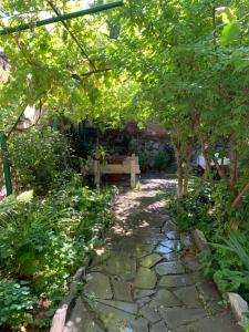 a garden with a bench sitting under a tree at Guests house Qotukner in Karbi