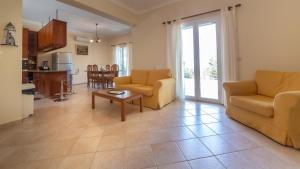 a living room with two chairs and a table at Villa Afrato in Kefallonia