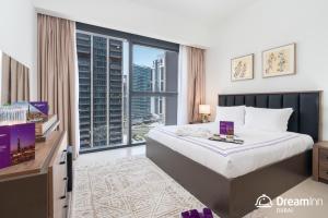 ドバイにあるDream Inn - Act One Act Two Apartment, Downtown Dubaiのベッドと大きな窓があるホテルの部屋