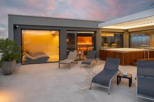 a patio with chairs and a bed in a room at Corallo Wellness Hotel in Diano Marina