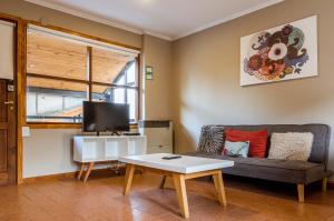 uma sala de estar com um sofá e uma mesa em BOG Angostura Apartments em Villa La Angostura