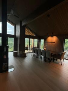 a dining room with a table and chairs and windows at Sogndal Chalet in Sogndal