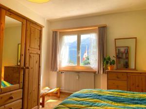 Schlafzimmer mit einem Bett und einem Fenster in der Unterkunft window on the green in Poschiavo