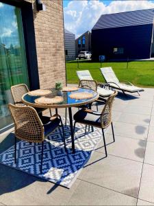 a group of chairs and tables on a patio at Makin' Memories - Apartamentai Monciškėse in Palanga