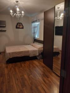 sypialnia z 2 łóżkami i żyrandolem w obiekcie St Pauls Bay Luxury 2 bedroom Apartment Blue Water Suite Flat 36 w mieście St Paul's Bay