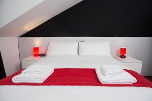 a bedroom with a white bed with two red lamps at The Queen Luxury apartments - Villa Giorgia in Dudelange