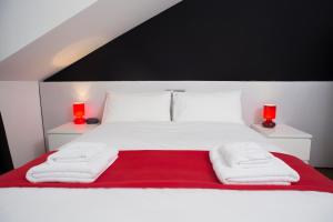 1 dormitorio con 1 cama blanca y 2 lámparas rojas en The Queen Luxury apartments - Villa Giorgia en Dudelange