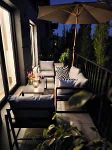 a patio with two chairs and an umbrella and a table at Apartament Wietrznia z tarasem, ogródkiem, parkingiem, na prestiżowym osiedlu obok rezerwatu przyrody NEW!!! in Kielce +70 photos