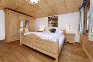 a bedroom with a large bed and a wooden ceiling at Veronikas Chalet in Sankt Gallenkirch