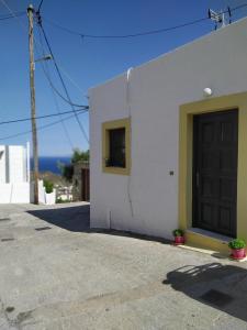 a white building with a black door and a window at Patmos house Leo & Mary in Patmos