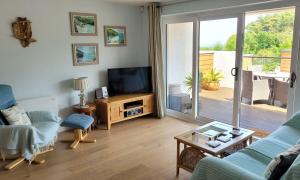 uma sala de estar com um sofá e uma televisão em Dunlin 3 - The Cove em Brixham
