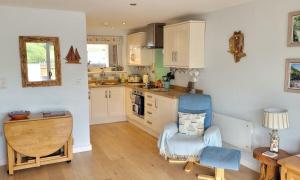 - une cuisine avec une table, une chaise et un bureau dans l'établissement Dunlin 3 - The Cove, à Brixham