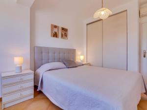 um quarto com uma cama branca e uma cómoda branca em AL - Apartamento Quinta do Romão em Quarteira