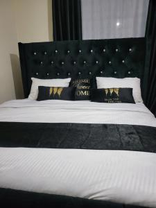 Schlafzimmer mit einem großen Bett mit einem schwarzen Kopfteil in der Unterkunft G&G Executive Homes NAKURU in Nakuru