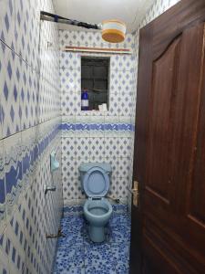 een badkamer met een toilet met blauwe en witte tegels bij G&G Executive Homes NAKURU in Nakuru