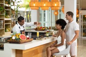 a group of people standing around a bar with a chef at Meliá Punta Cana Beach Wellness Inclusive - Adults only in Punta Cana