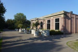 a brick building with tables and trees in front of it at Fletcher Landgoedhotel Renesse in Renesse