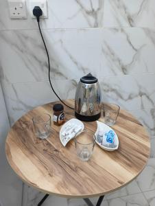 a table with a coffee pot and glasses on it at ابو عامر للشقق المفروشه in Al ‘Awālī