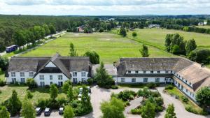 una vista aérea de una casa grande con patio en Friesenhof Hotel-Restaurant-Reitanlage en Trassenheide