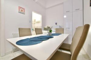een witte eettafel met blauwe servetten erop bij Standard Apartment by Hi5 - Múzeum 5 in Boedapest