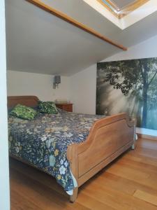 1 dormitorio con 1 cama y una pintura en la pared en L'île d'Amélie, en Ciney