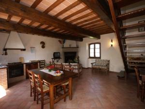 cocina y sala de estar con mesa y sillas en Nice apartment with pool and beautiful garden, en Montone