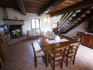 comedor con mesa de madera y sillas en Nice apartment with pool and beautiful garden, en Montone