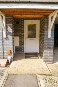 a front door of a brick building with a white door at Millward Homes in Bletchley