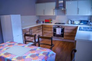a kitchen with a table and a kitchen with white cabinets at Millward Homes in Bletchley