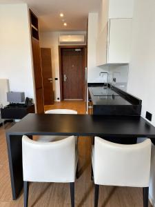 a kitchen with a black table and white chairs at Sea breeze Villa in Nardaran