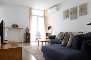 プライアにある2 bdr cozy apt near Praça Center, AC & Fast Wi-Fiの青いソファとテーブルのあるリビングルーム