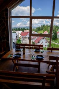 una mesa en una habitación con una ventana grande en Premium Apartments en Žabljak